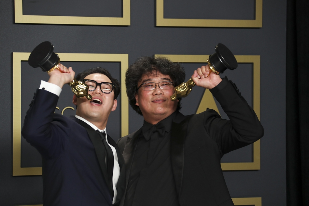 Han Jin Won y Bong Joon Ho (d), los ganadores de la noche, con los Oscar a mejor película ('Parásitos'), mejor película extranjera, mejor director y mejor guion original  / ALLEN J. SCHABEN