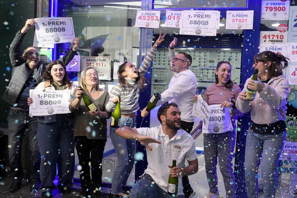 Los propietarios y trabajadores de la administración de lotería Las Arenas de Barcelona, celebran haber repartido dos series del Gordo